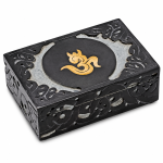Caja rectangular negra con símbolo Om dorado y motivos vegetales en relieve en la tapa y los laterales.