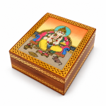 Vista superior de la tapa de la caja con Ganesha y marco ornamental dorado.