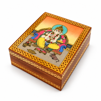 Vista superior de la tapa de la caja con Ganesha y marco ornamental dorado.