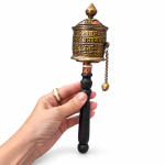 Mano sujetando un molinillo tibetano de oración