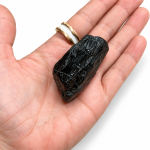 Piedra redondeada de turmalina negra sobre una mano